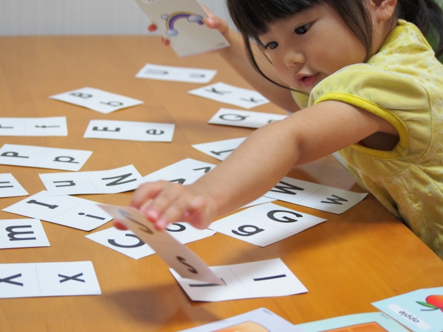 幼児が英語カードを取っている